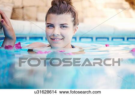 Picture - Surface level portrait of teenage girl in swimming pool. Fotosearch
