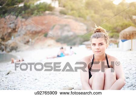 "Teenage girl hugging knees sitting on beach, Javea, Spain" View Large Photo Image Stock Photo - "Teenage girl hugging knees sitting on beach, Javea, Spain". Fotosearch