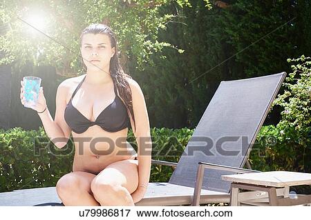 Teenage girl wearing bikini sitting on sun lounger View Large Photo Image Stock Photo - Teenage girl wearing bikini sitting on sun lounger. Fotosearch