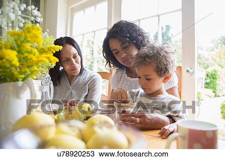 Stock Image - Three generation family eating breakfast together. Fotosearch
