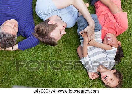 Picture - Three generation family fooling around in garden. Fotosearch