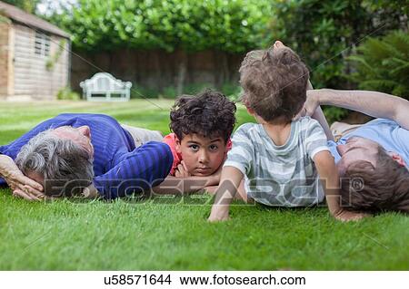 Picture - Three generation family fooling around in garden. Fotosearch