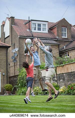 Three generation family playing with football in garden View Large Photo Image Picture - Three generation family playing with football in garden. Fotosearch