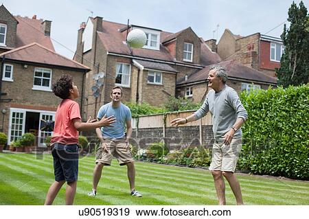 Three generation family playing with football in garden View Large Photo Image Stock Photo - Three generation family playing with football in garden. Fotosearch