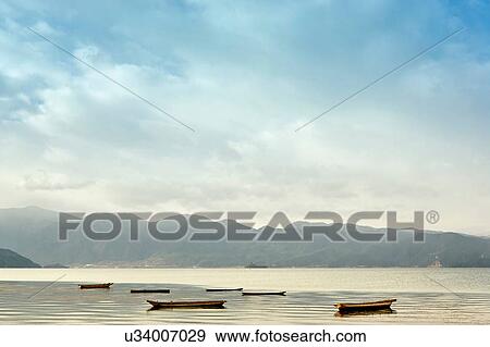 "Tranquil view of moored fishing boats on Lugu Lake, Yunnan, China" View Large Photo Image Stock Photo - "Tranquil view of moored fishing boats on Lugu Lake, Yunnan, China". Fotosearch