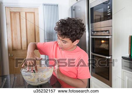 Young boy eating cake mix from bowl View Large Photo Image Stock Photo - Young boy eating cake mix from bowl. Fotosearch