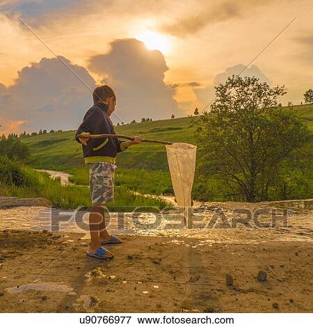 "Young boy fishing in stream, using fishing net, low angle view" View Large Photo Image Stock Photo - "Young boy fishing in stream, using fishing net, low angle view". Fotosearch