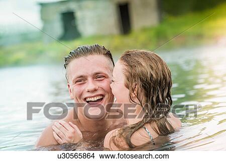 Picture - "Young couple laughing in Secret Lagoon hot spring (Gamla Laugin), Fludir, Iceland". Fotosearch
