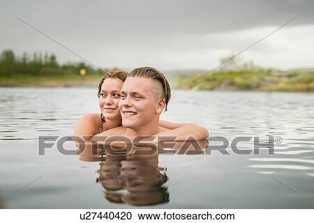 "Young couple looking sideways from Secret Lagoon hot spring (Gamla Laugin), Fludir, Iceland" View Large Photo Image Stock Image - "Young couple looking sideways from Secret Lagoon hot spring (Gamla Laugin), Fludir, Iceland". Fotosearch
