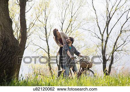 Young couple on bicycle in rural woodland View Large Photo Image Stock Image - Young couple on bicycle in rural woodland. Fotosearch