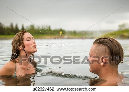 "Young couple squirting water in Secret Lagoon hot spring (Gamla Laugin), Fludir, Iceland" View Large Photo Image Stock Image - "Young couple squirting water in Secret Lagoon hot spring (Gamla Laugin), Fludir, Iceland". Fotosearch