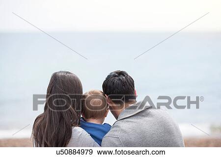 "Young family looking at sea view, rear view" View Large Photo Image Stock Photo - "Young family looking at sea view, rear view". Fotosearch