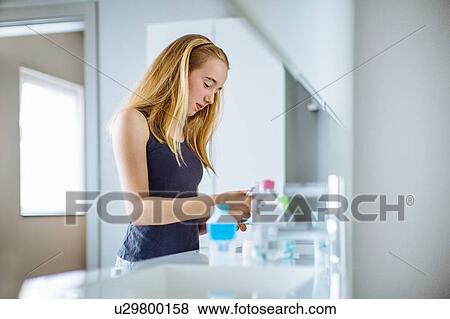 "Young girl in bathroom, squeezing toothpaste onto brush" View Large Photo Image Stock Photo - "Young girl in bathroom, squeezing toothpaste onto brush". Fotosearch