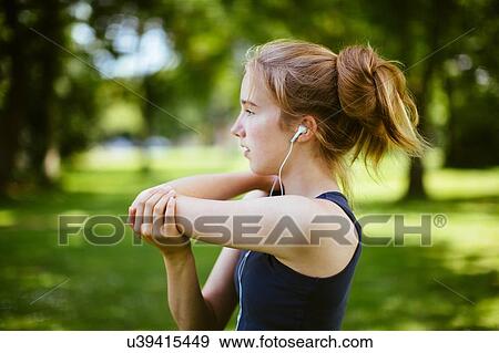 "Young girl in park, doing arm stretches" View Large Photo Image Stock Photo - "Young girl in park, doing arm stretches". Fotosearch