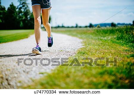 "Young girl in park, running on pathway, low section" View Large Photo Image Picture - "Young girl in park, running on pathway, low section". Fotosearch