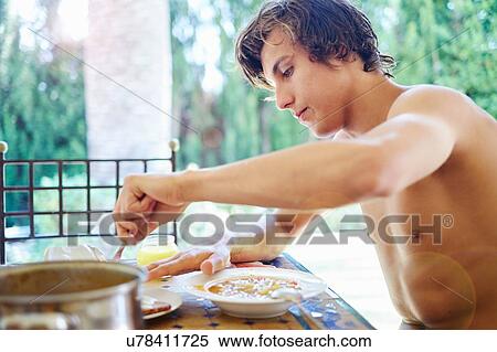 Young man eating lunch on holiday apartment patio View Large Photo Image Stock Photography - Young man eating lunch on holiday apartment patio. Fotosearch