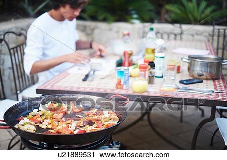 Young man eating stir fried lunch at patio table View Large Photo Image Stock Image - Young man eating stir fried lunch at patio table. Fotosearch