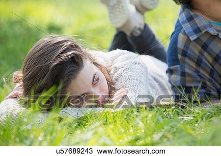 Young woman lying on picnic blanket looking away View Large Photo Image Stock Image - Young woman lying on picnic blanket looking away. Fotosearch