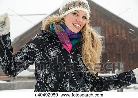 Stock Image - Young woman posing in front of hut. Fotosearch