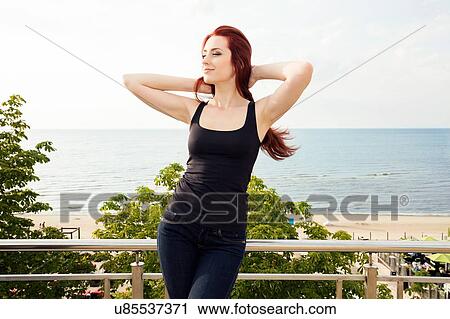 Young woman relaxing by beach View Large Photo Image Stock Image - Young woman relaxing by beach. Fotosearch