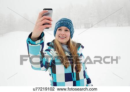 "Young woman taking selfie in snow, Sattelbergalm, Tirol, Austria" View Large Photo Image Stock Image - "Young woman taking selfie in snow, Sattelbergalm, Tirol, Austria". Fotosearch