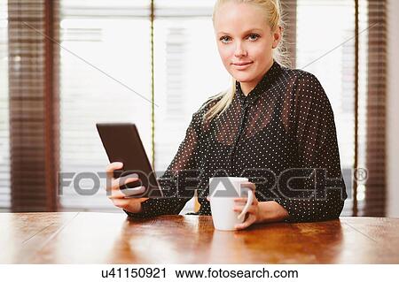 Stock Image - Young woman using digital tablet. Fotosearch