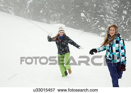 Stock Photo - "Young women playing in snow, Sattelbergalm, Tirol, Austria". Fotosearch