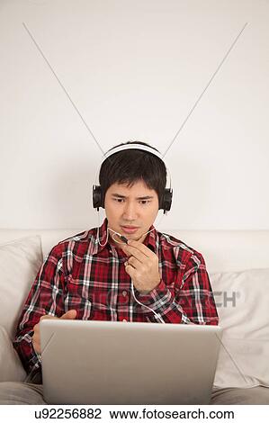 Stock Image - Angry man talking with phones. Fotosearch