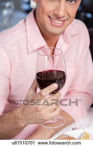 Beautiful man holding a wineglass View Large Photo Image Stock Image - Beautiful man holding a wineglass. Fotosearch