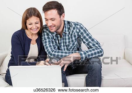 Stock Photograph - Beautifull couple using the computer. Fotosearch