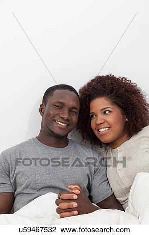 Stock Image - Black couple in love in the bed. Fotosearch