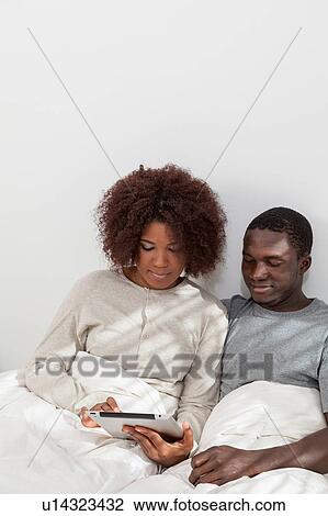Stock Image - Black couple in love using the computer. Fotosearch