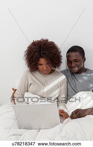 Stock Photo - Black couple in love using the computer. Fotosearch
