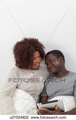 Stock Image - Black couple using the ipad. Fotosearch
