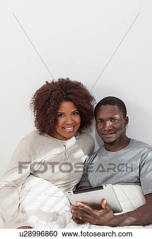 Stock Image - Black couple using the ipad. Fotosearch