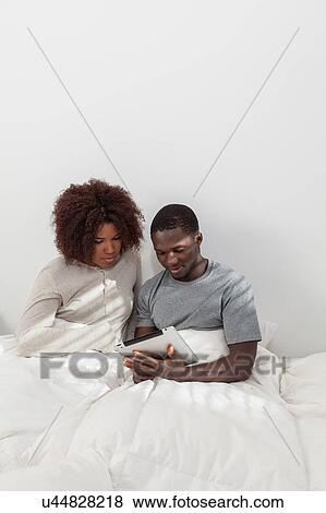 Stock Photo - Black couple using the ipad. Fotosearch