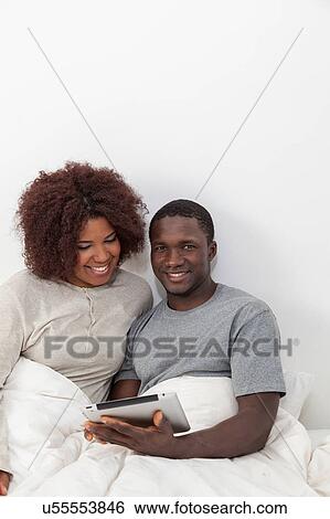 Black couple using the ipad View Large Photo Image Stock Photograph - Black couple using the ipad. Fotosearch