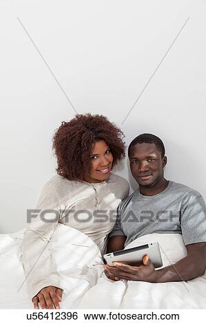 Stock Photograph - Black couple using the ipad. Fotosearch