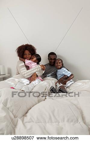 Stock Photo - Black family in the bed. Fotosearch