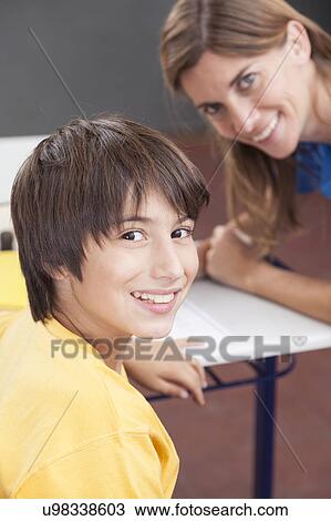 Boy and teacher looking at camera View Large Photo Image Stock Image - Boy and teacher looking at camera. Fotosearch