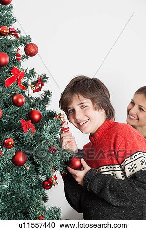Boy decorating the christmas tree View Large Photo Image Stock Image - Boy decorating the christmas tree. Fotosearch