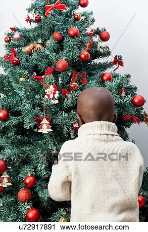 Boy decorating the christmas tree View Large Photo Image Stock Image - Boy decorating the christmas tree. Fotosearch