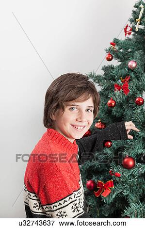 Stock Photo - Boy decorating the christmas tree. Fotosearch
