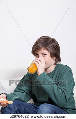 Boy drinking a oranje juice View Large Photo Image Stock Image - Boy drinking a oranje juice. Fotosearch