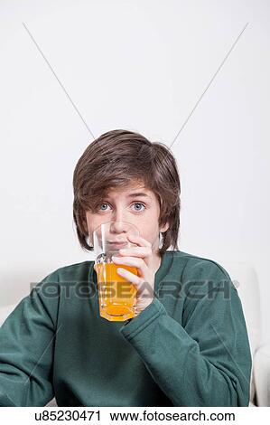 Stock Image - Boy drinking a oranje juice. Fotosearch