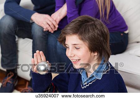 Stock Photo - Boy holding a ball of the christmas tree. Fotosearch
