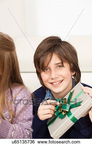 Boy holding a giftbox for christmas View Large Photo Image Stock Photograph - Boy holding a giftbox for christmas. Fotosearch