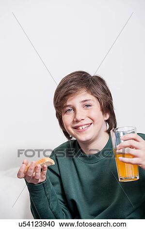 Boy holding a juice and a toast View Large Photo Image Stock Image - Boy holding a juice and a toast. Fotosearch