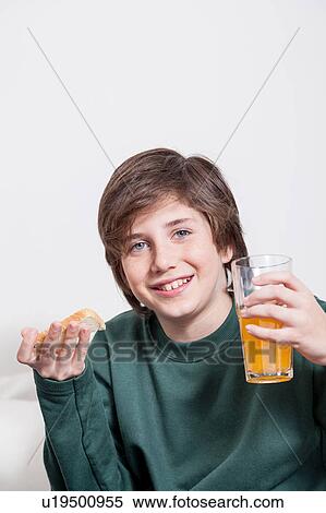 Stock Photography - Boy holding a juice and a toast. Fotosearch