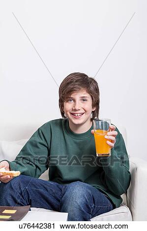 Boy holding a orange juice View Large Photo Image Stock Image - Boy holding a orange juice. Fotosearch